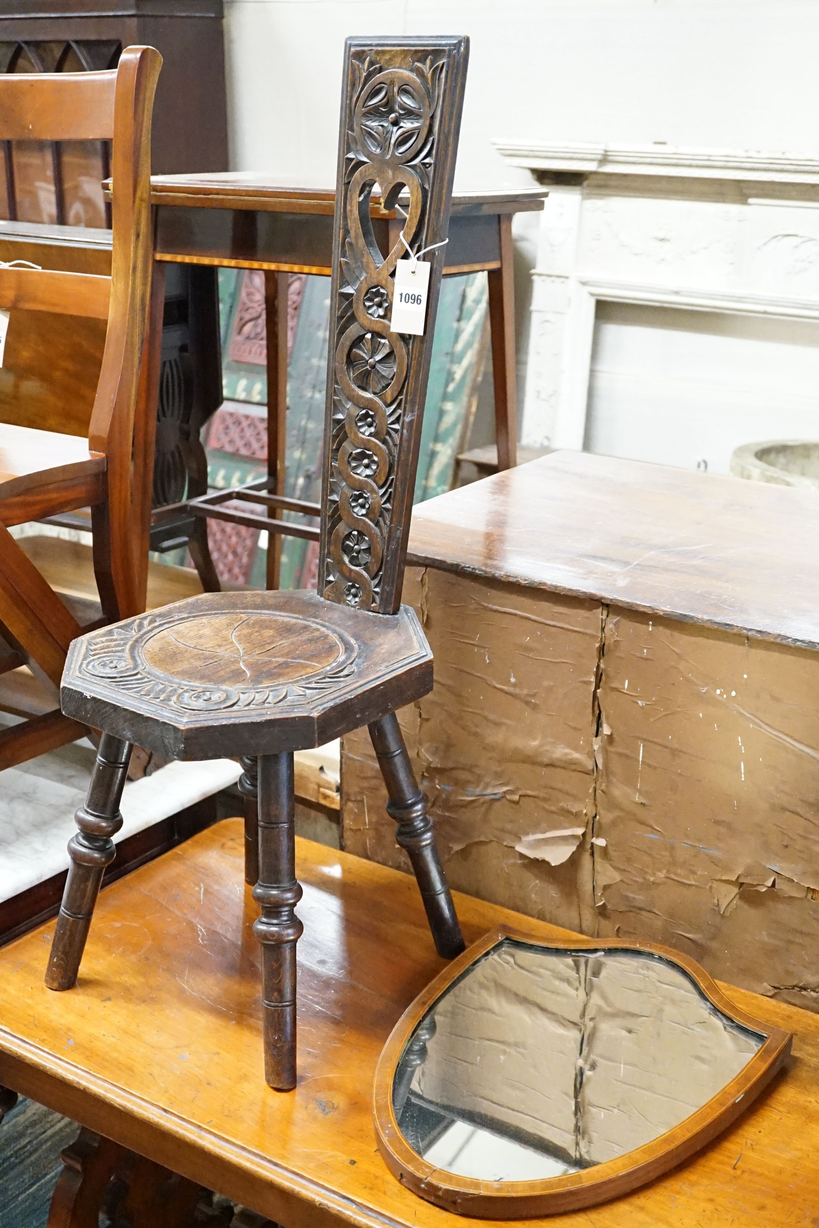 An Edwardian inlaid mirror and a carved stool.